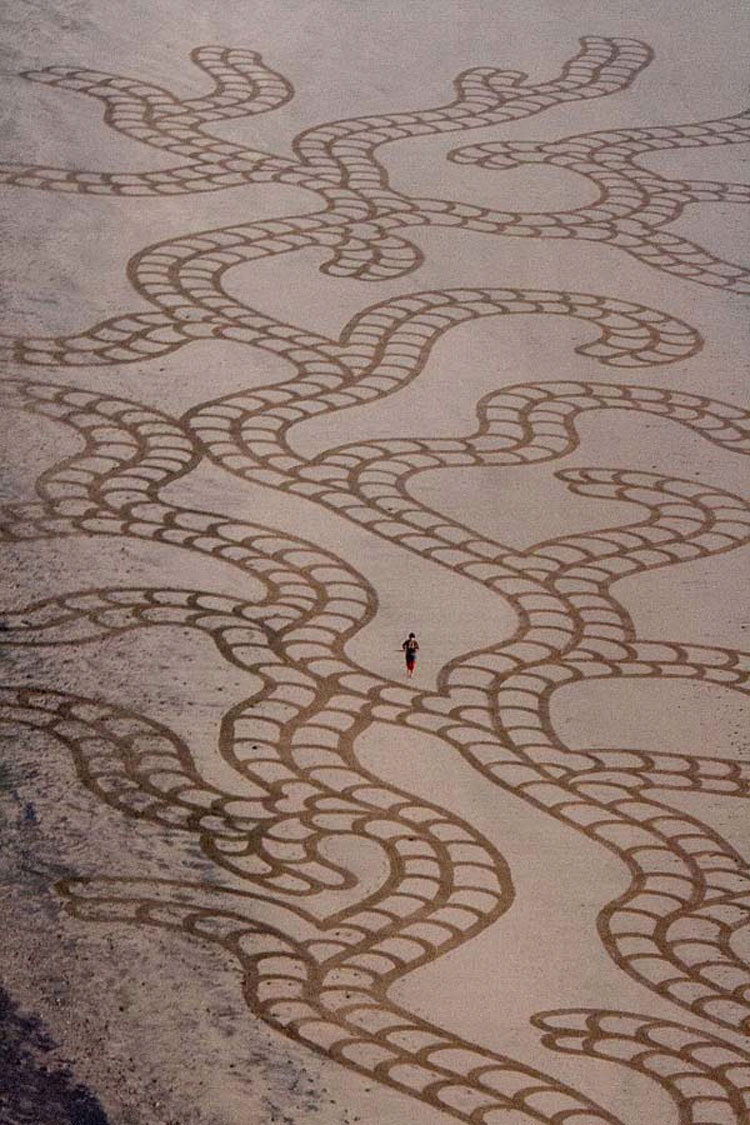 Un hombre hace algo con un simple rastrillo en la playa. Cuando nos alejamos para verlo... ¡WOOOW!