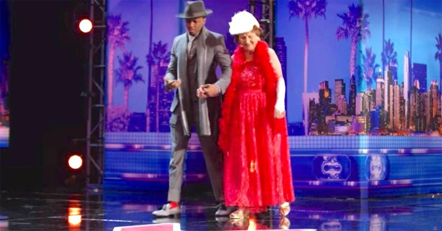 Conducen a la participante de 90 años hasta el escenario. Mira bien su falda roja ...