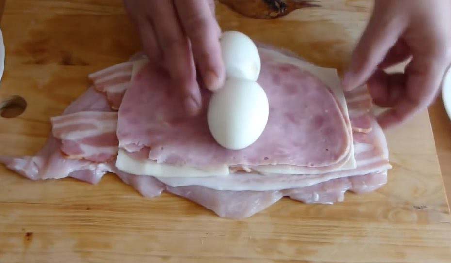 Enrolla huevos cocidos en pollo y cuando lo saca del horno sorprende a la gente